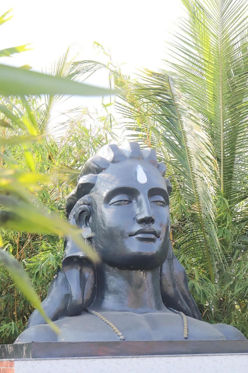 Adiyogi bust set among palms and bamboo on the grounds at Mytri Farmhouse near Kondapochamma Sagar, Siddipet