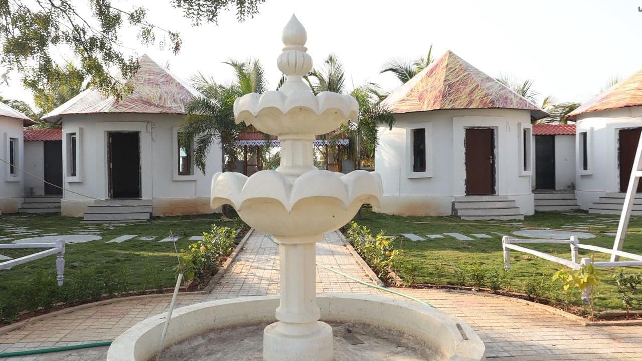 Fountain and guest cottages on the open lawn at Mytri Farmhouse near Kondapochamma Sagar, Siddipet