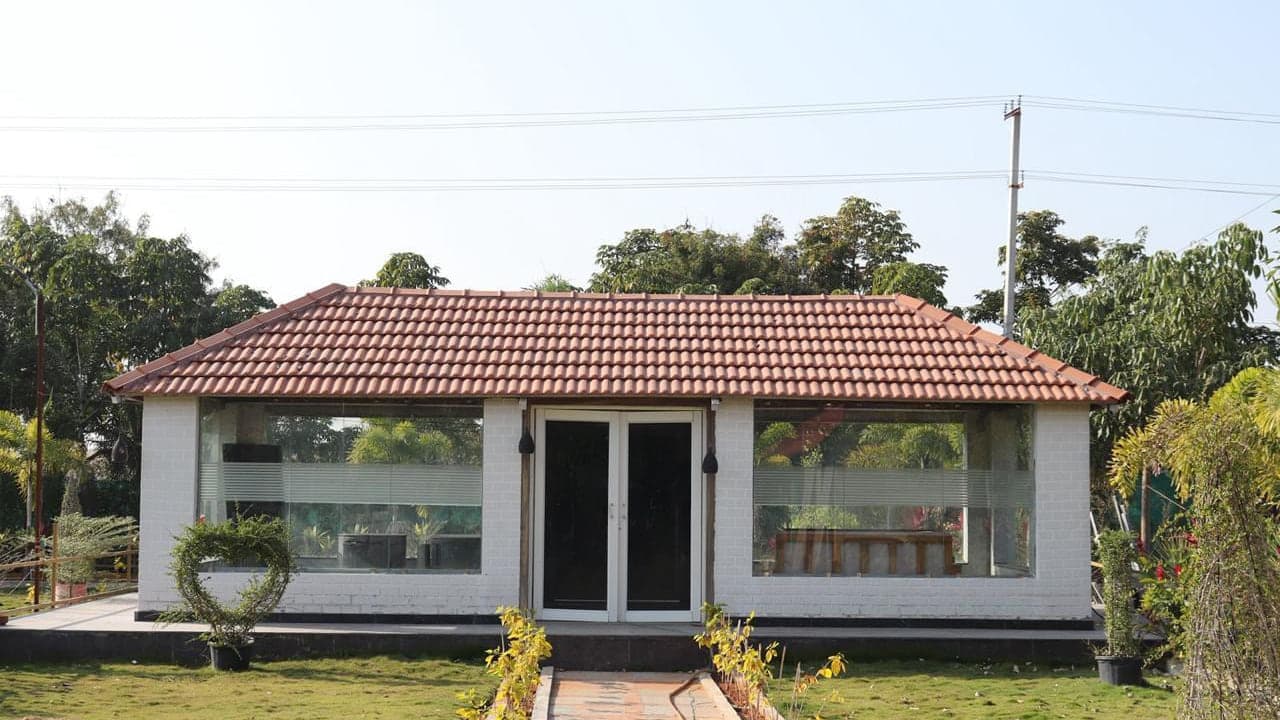 Glass-walled dining pavilion at Mytri Farmhouse near Kondapochamma Sagar, Siddipet