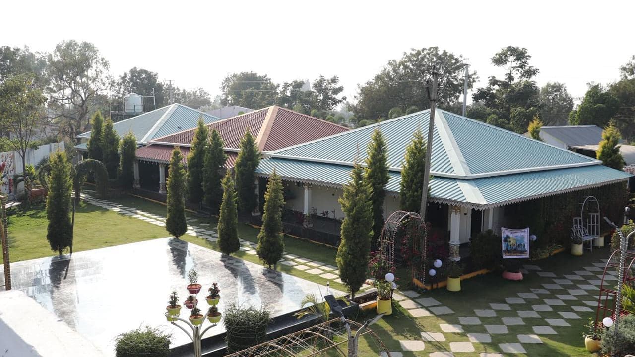 Guest room block and lawns seen from above at Mytri Farmhouse near Kondapochamma Sagar, Siddipet