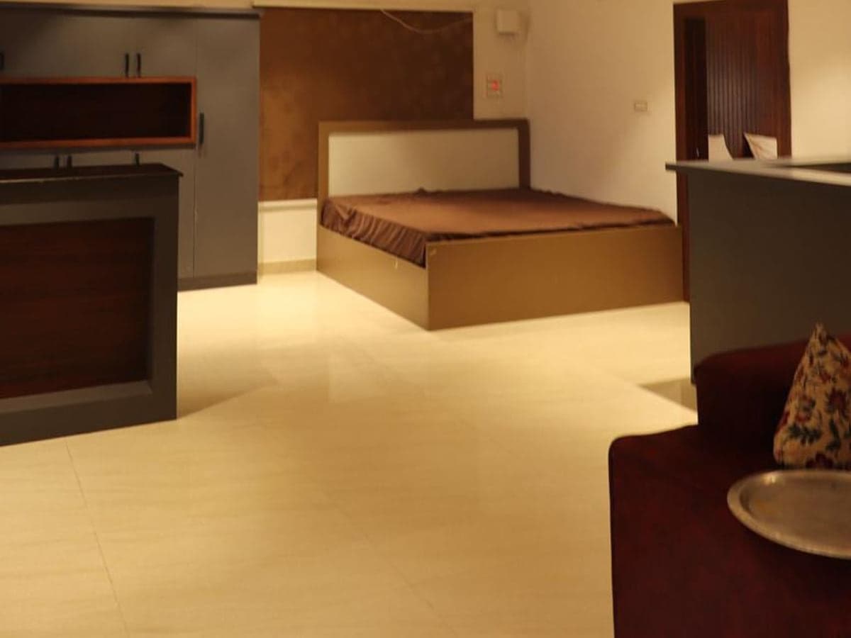 Bed and seating area inside one of the larger units at Mytri Farmhouse near Kondapochamma Sagar, Siddipet
